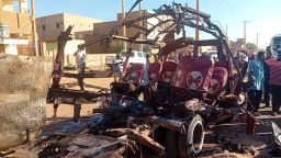 People gather near a destroyed vehicle, following shelling by the Rapid Support Forces, in Omdurman, Sudan, December 10, 2024.
