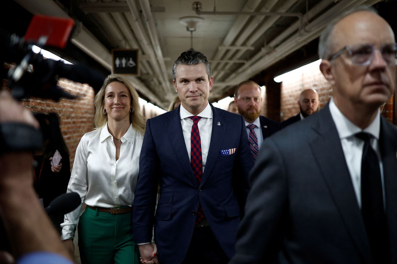 Pete Hegseth walks with his wife after a meeting in the Russell Senate Office Building on Capitol Hill in Washington, DC, on December 17.