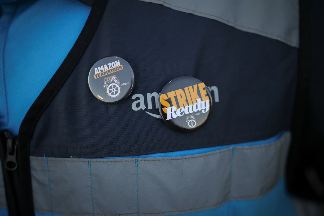 A striking worker wears badges on their Amazon clothing, as they picket outside of the Amazon DAX5 warehouse, in City of Industry, California, on December 19.