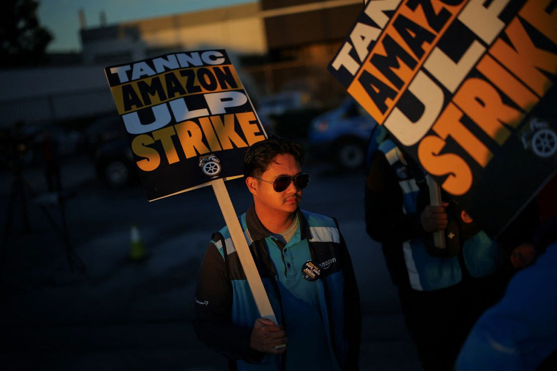 Striking workers hold signs outside an Amazon warehouse in City of Industry, California, on December 19.