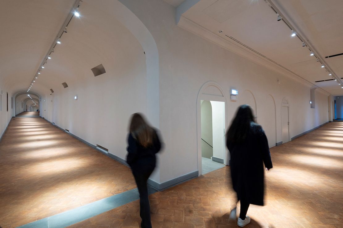 People walk in the Vasari Corridor, a Renaissance-era passageway in Florence, Italy.