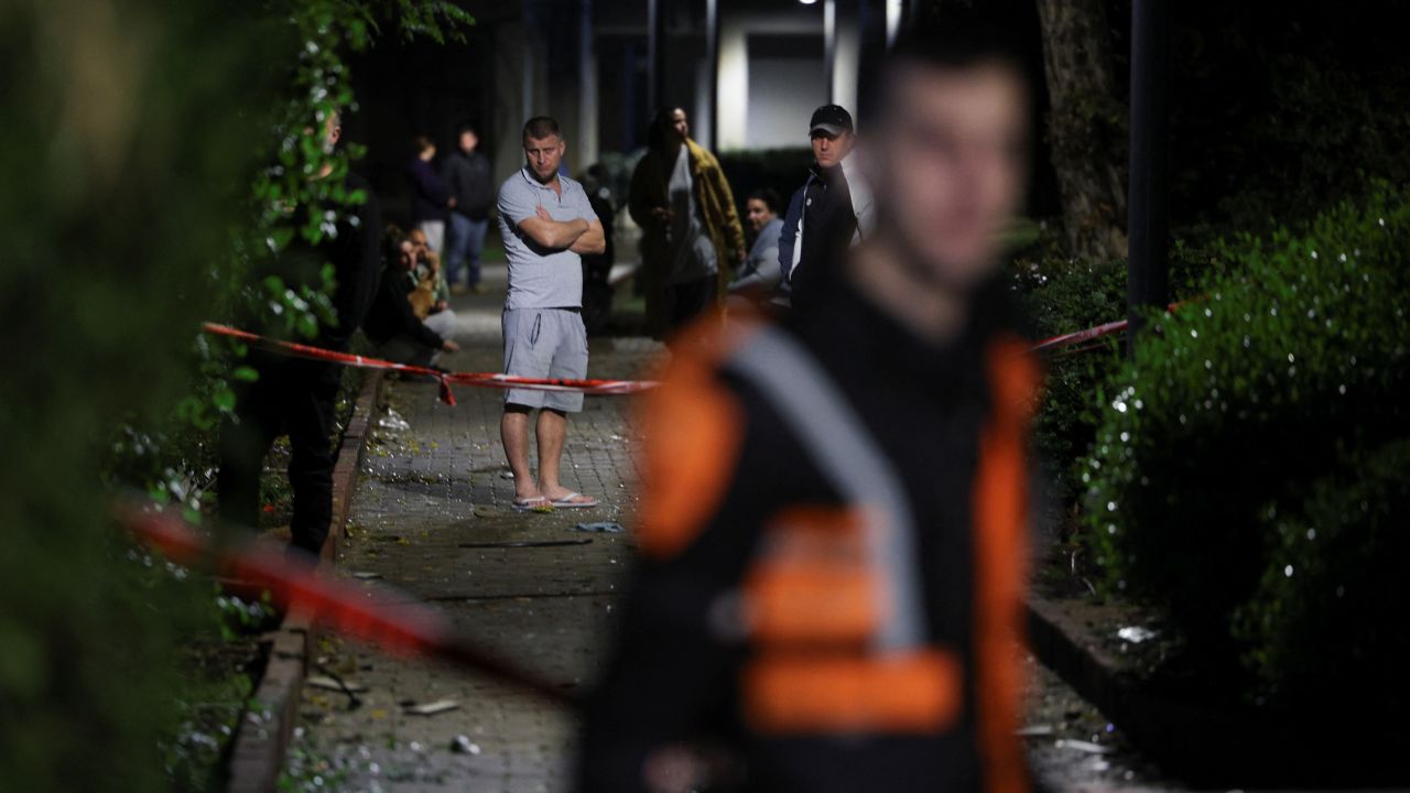 People gather at the scene of a missile strike that, according to Israel’s military, was launched from Yemen and landed in Jaffa, south of Tel Aviv, Israel, December 21, 2024. REUTERS/ Stoyan Nenov
