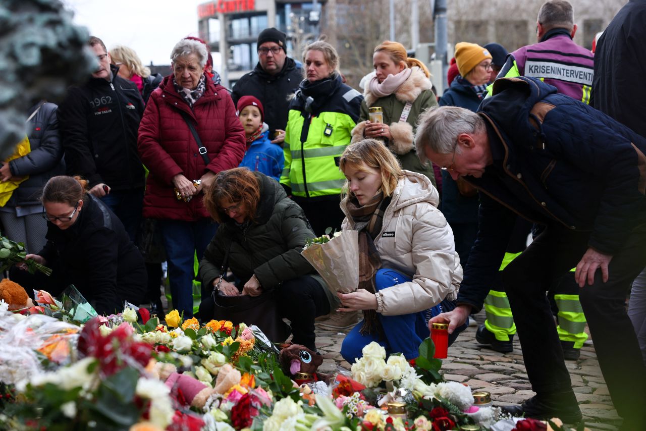 People leave candles and flowers near the Christmas market in Magdeburg, Germany, on December 21.