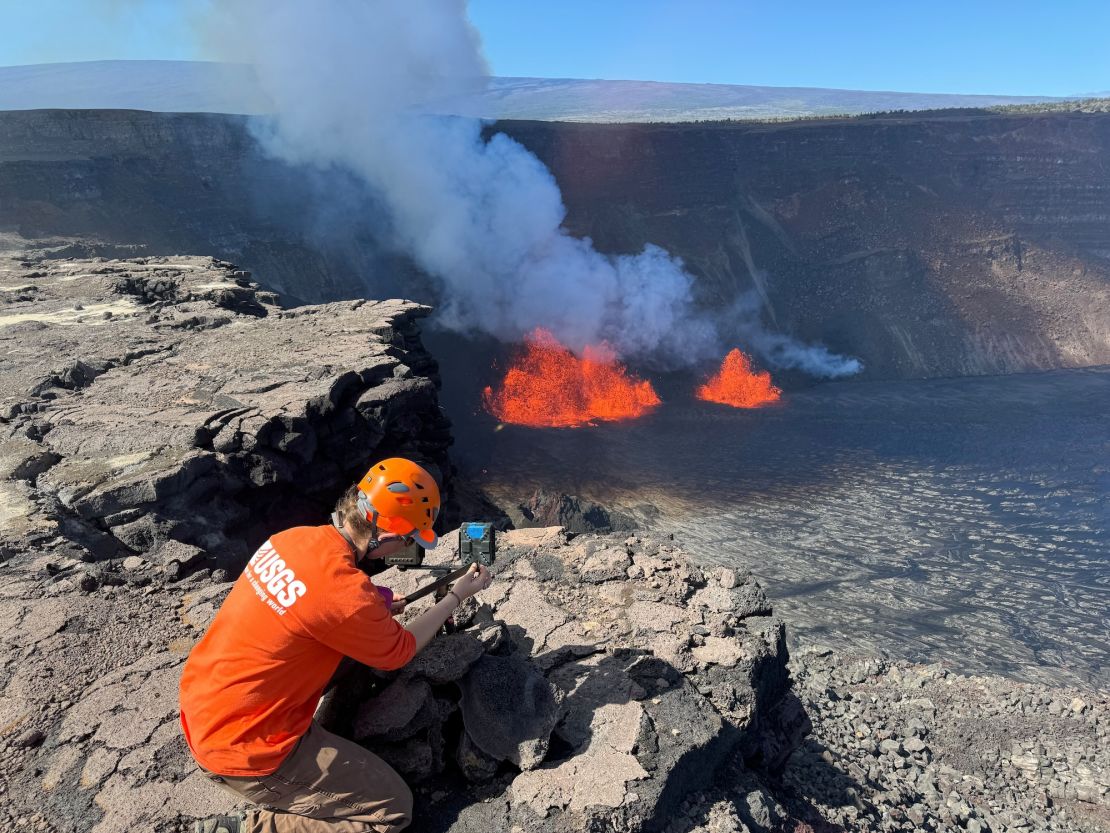 A U.S. Geological Survey Hawaiian Volcano Observatory geologist checks a webcam located on the rim of the caldera during a new eruption that began early at the Kilauea volcano in Hawaii. December 23, 2024.