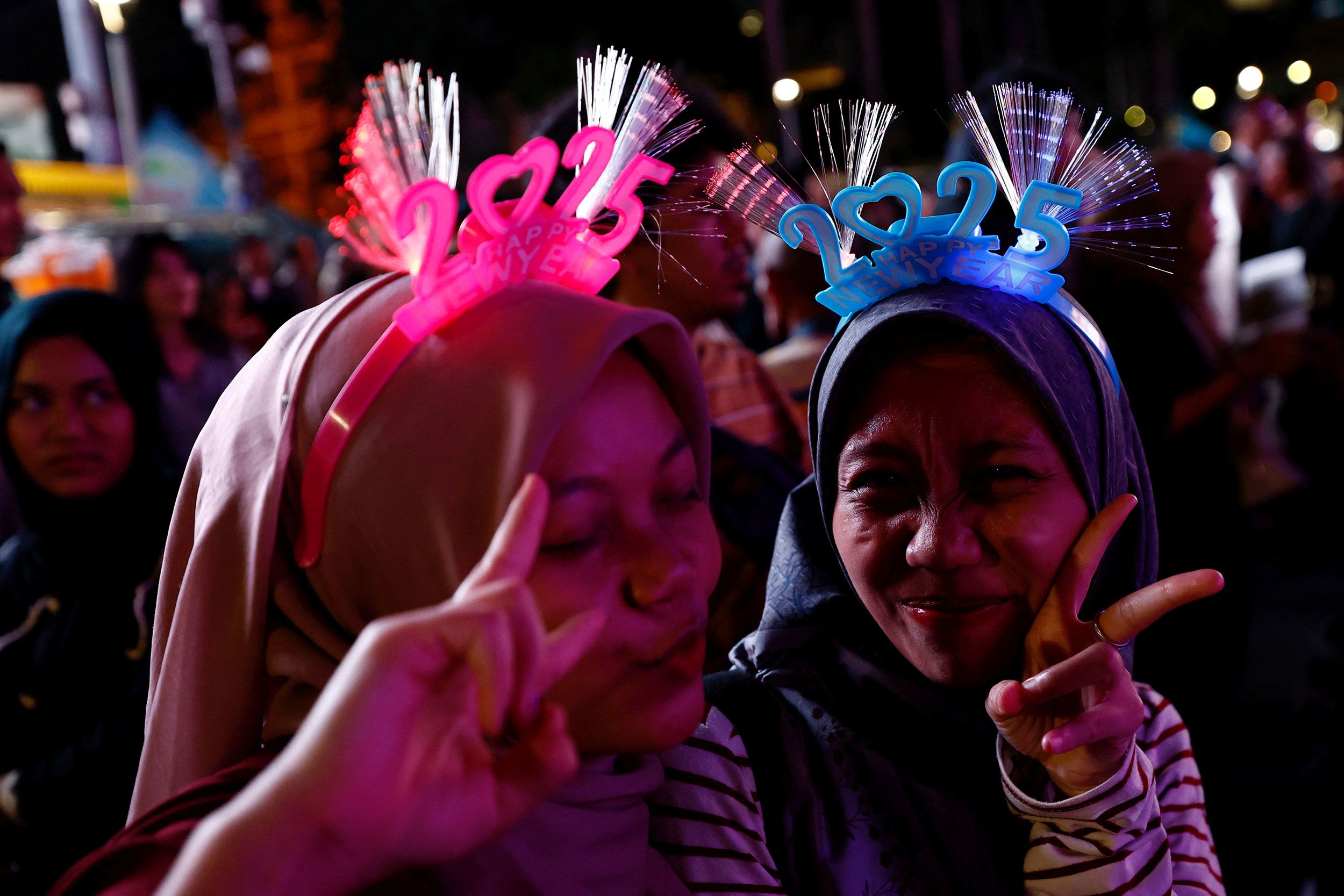 Women wear 2025 headbands as they attend celebrations in Jakarta.