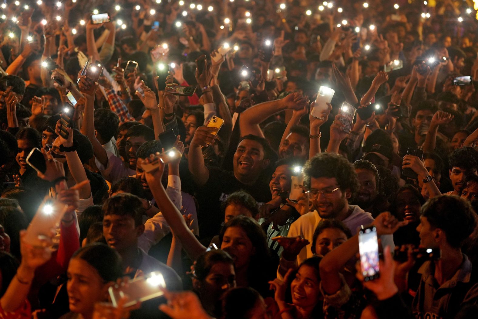 People flash lights from their cell phones as they attend New Year’s celebrations in Mumbai, India.