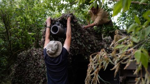 Ukrainian troops use camouflage netting to hide an American-supplied Abrams tank in eastern Ukraine.