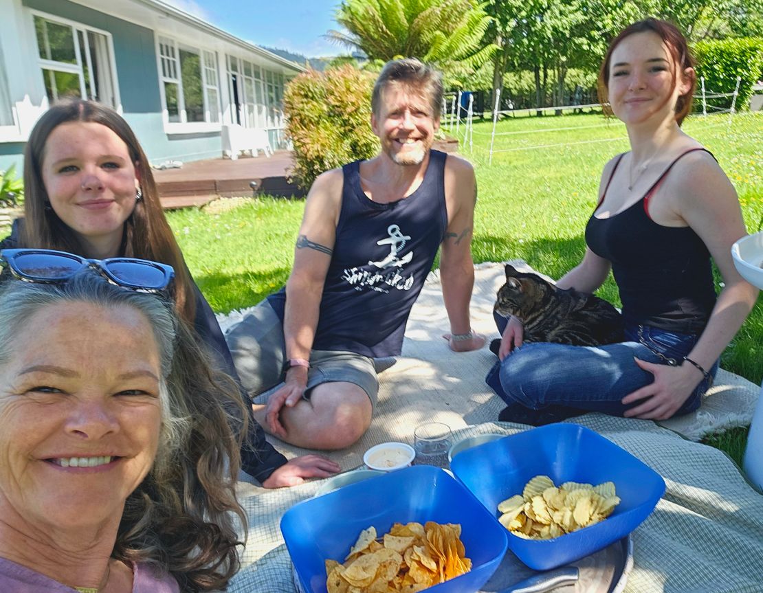 The couple, seen here with their two teenage daughters and cat, live in New Zealand.