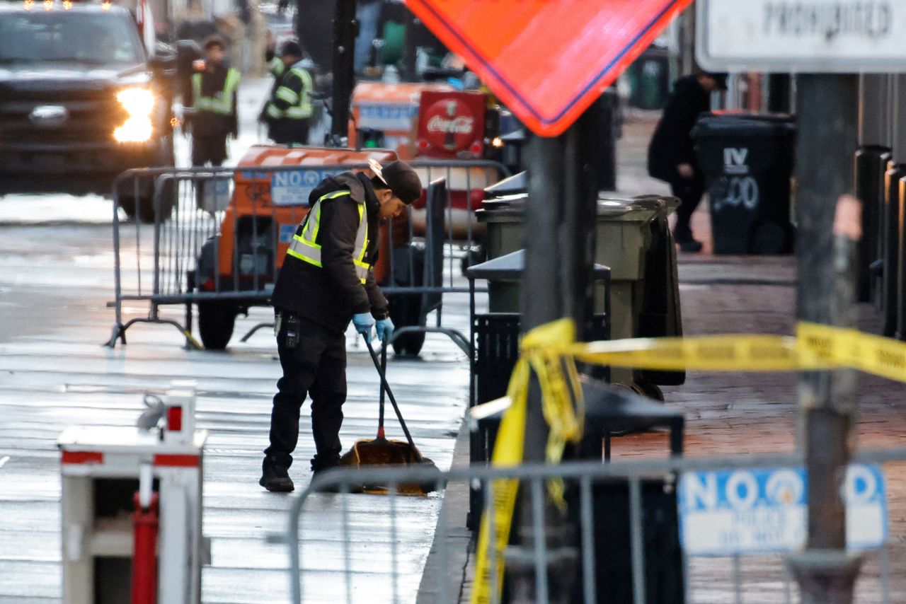 A worker cleans the street at the site, where a pickup truck rammed through a crowd the day before, in New Orleans on Thursday.