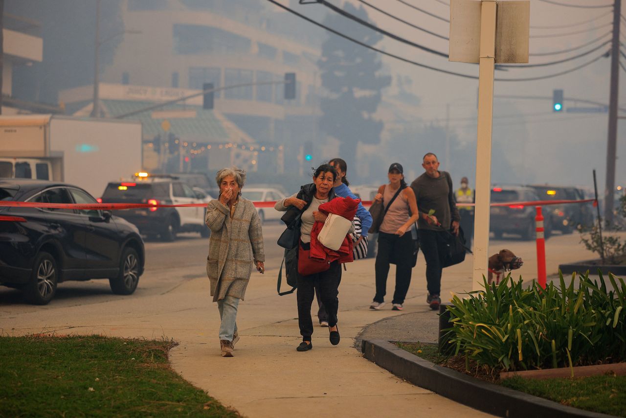 People evacuate, as a wildfire breaks-out near Pacific Palisades on the west side of Los Angeles on Tuesday.