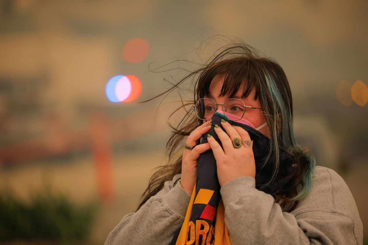 A person uses clothing to partially cover their face as a wildfire breaks out near Pacific Palisades on the west side of Los Angeles in Southern California, on January 7.