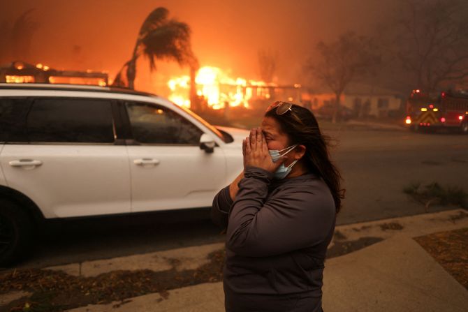 A woman reacts to the Eaton Fire in Altadena.