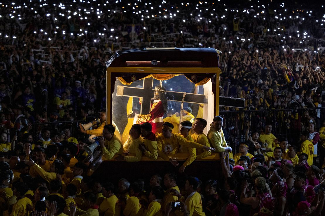 Filipino Catholic devotees surround the carriage carrying the ⁢statue ‌of the Black‌ Nazarene⁢ during its annual procession in Manila.