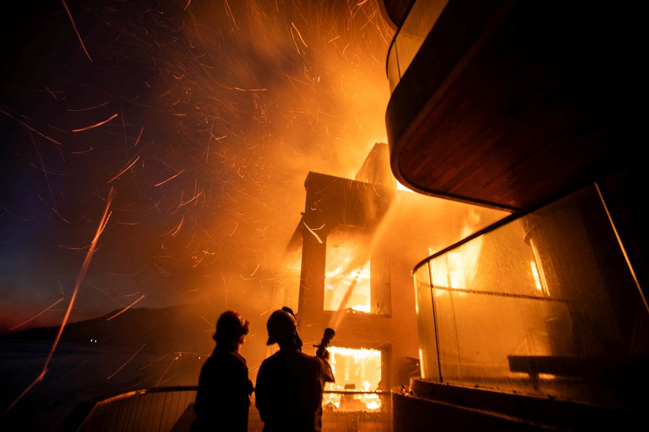 Firefighters battle the Palisades fire as it burns during a windstorm on the west side of Los Angeles, California, on January 8, 2025.