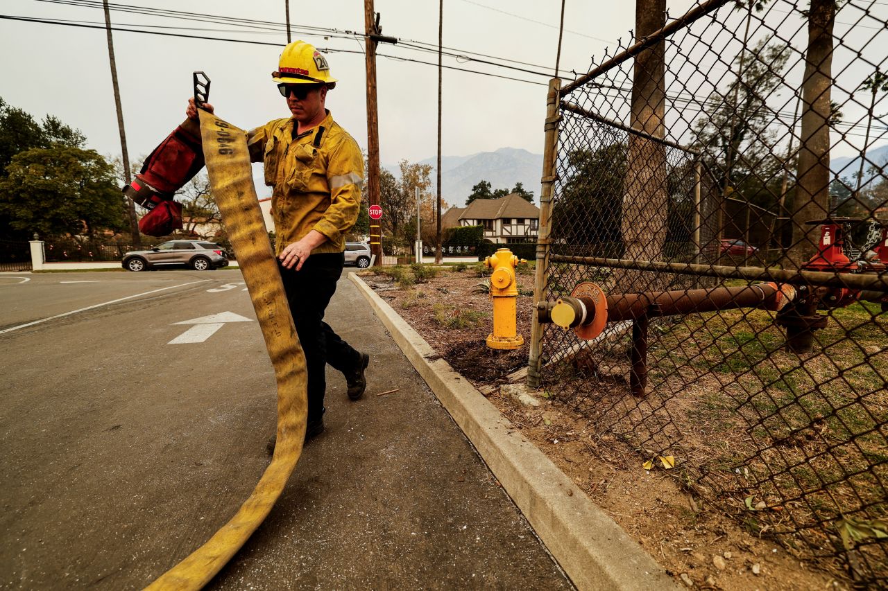 A firefighter walks away from an empty hydrant while fighting the Eaton Fire in Altadena, California, on Thursday.