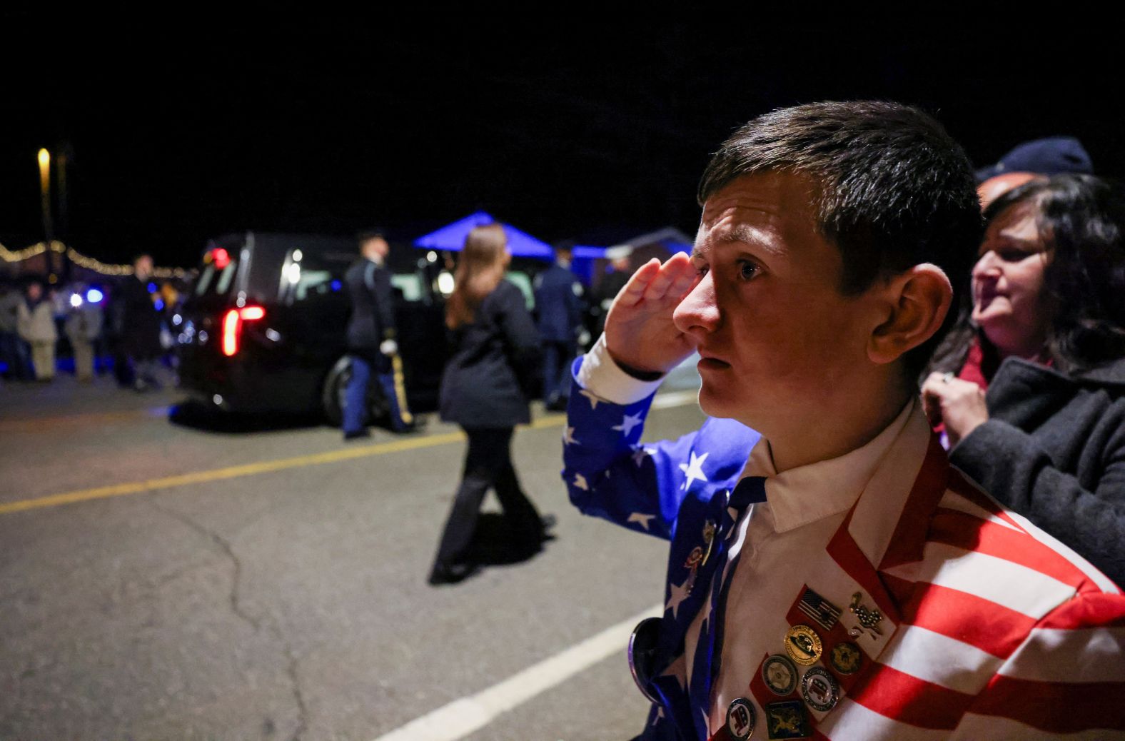 Reed Elliott, 14, salutes the motorcade carrying former US President Jimmy Carter's casket as it is driven through Plains, Georgia.