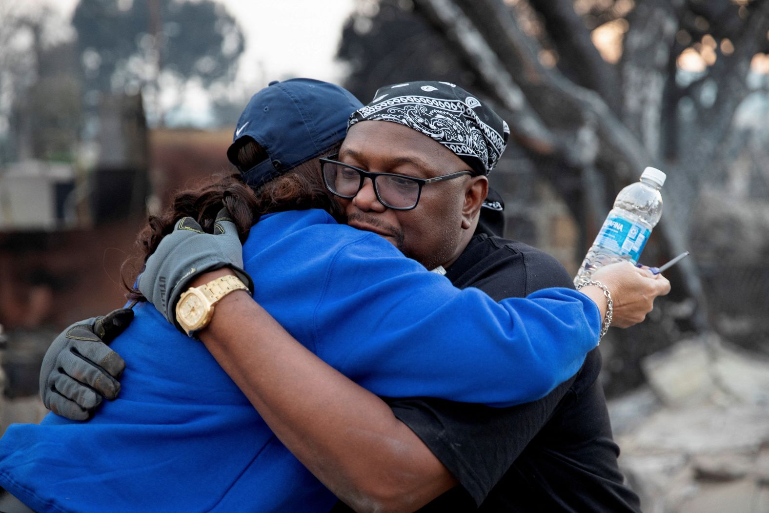 Desiree Johnson is embraced by her neighbor after her home was destroyed by the Eaton Fire.