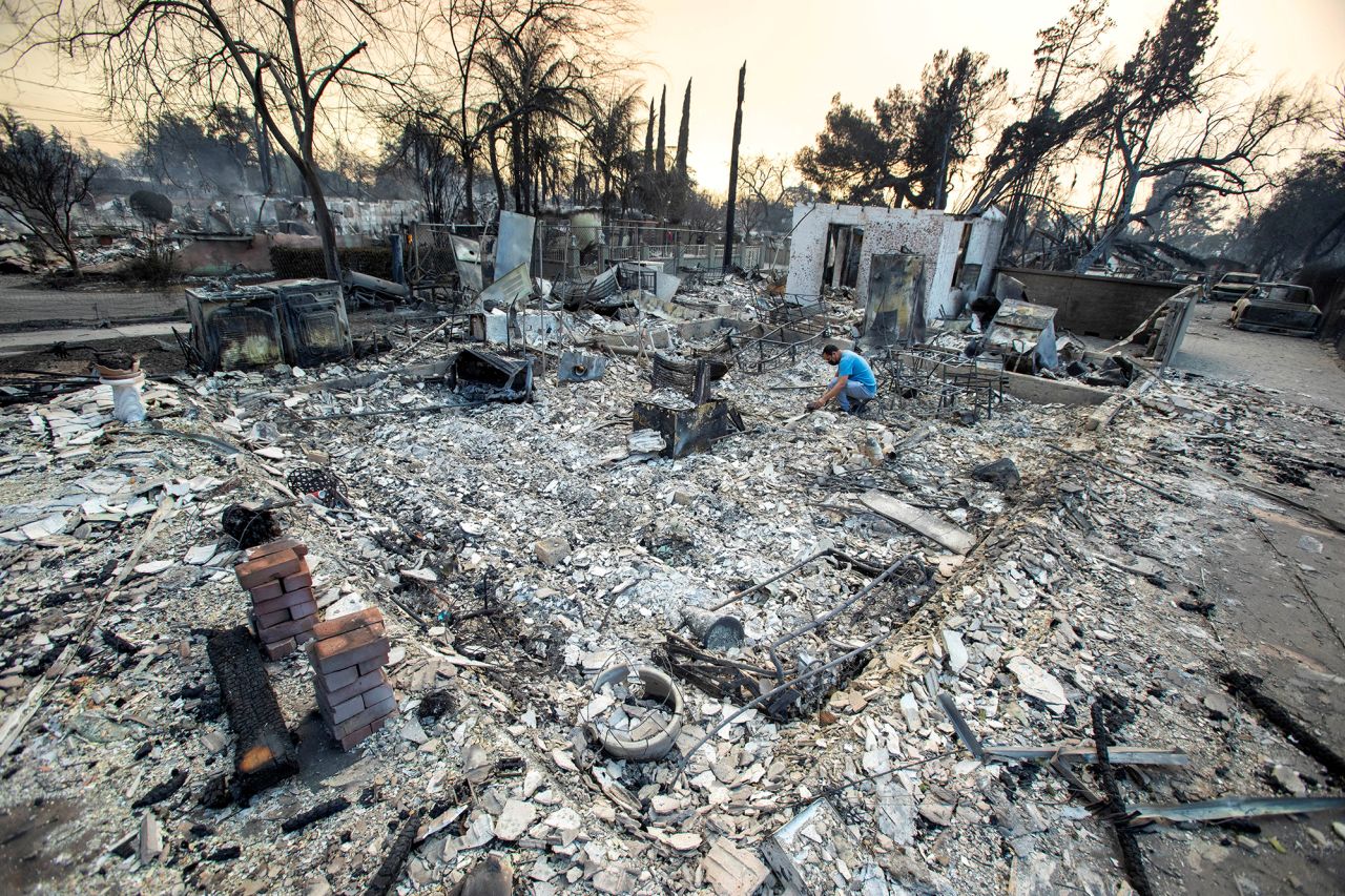 A man searches for belongings in the remains of his home in Altadena, California, on January 9.