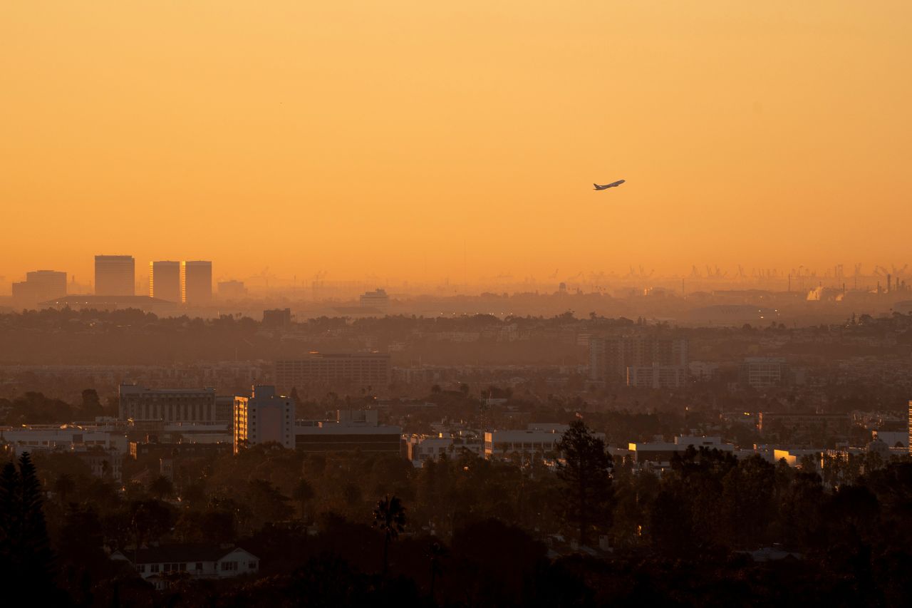 A plane takes off amidst smoke from the Palisades Fire in Los Angeles on Tuesday.