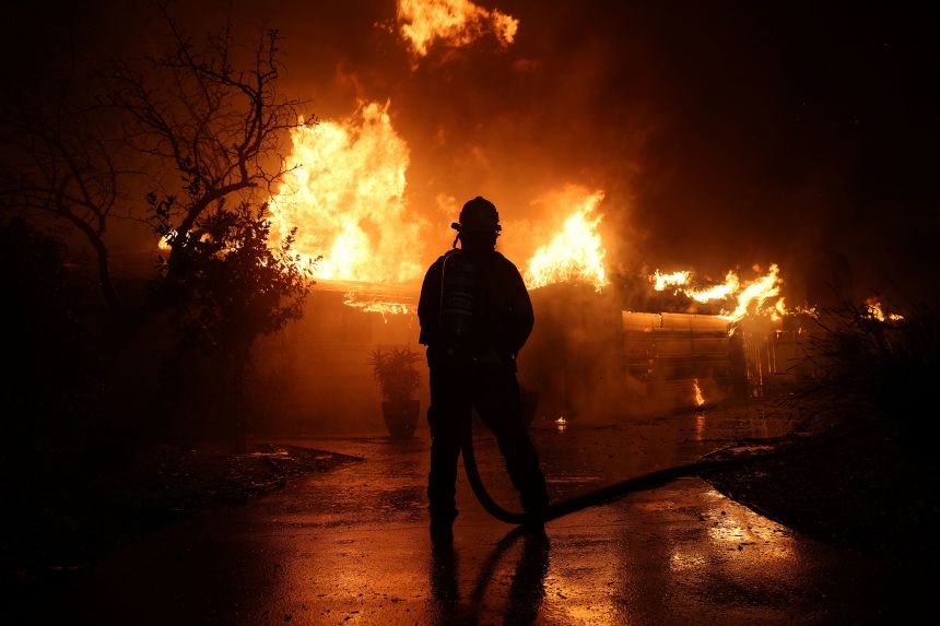 A firefighter holds a hose during the Eaton Fire in Pasadena, California, U.S., January 8, 2025.