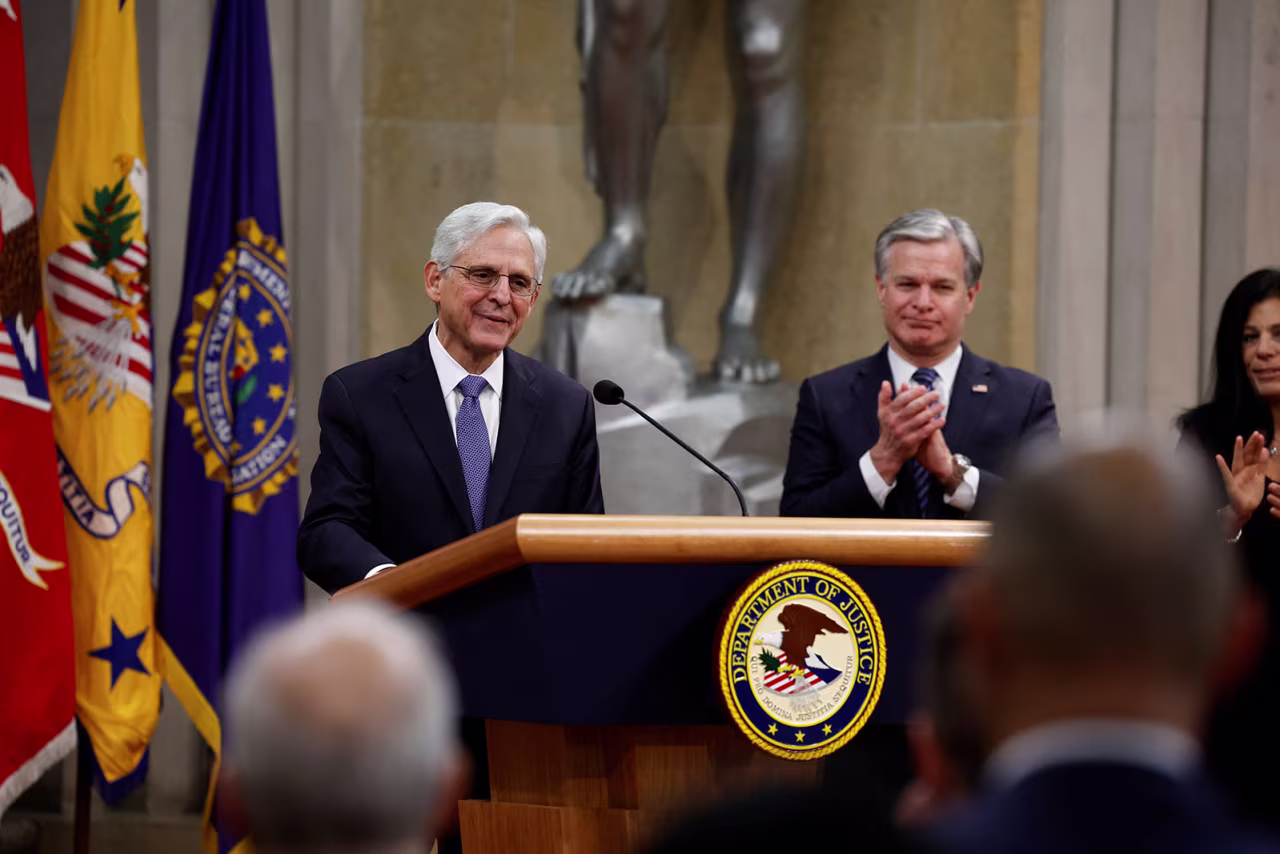 FBI Director Christopher Wray, right, applauds US Attorney General Merrick Garland as he delivers a farewell address to the Justice Department on Thursday.