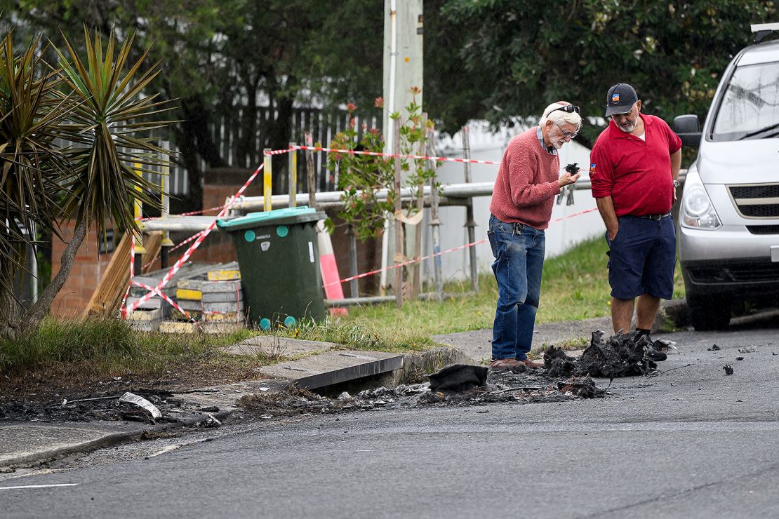 A resident inspects the burnt out remains of a car in Dover Heights, Sydney, Friday, January 17, 2025.