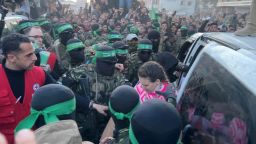Palestinian Hamas militants hand over hostages kidnapped during the October 7, 2023, attack on Israel, to members of the International Committee of the Red Cross in Gaza City, January 19, 2025.