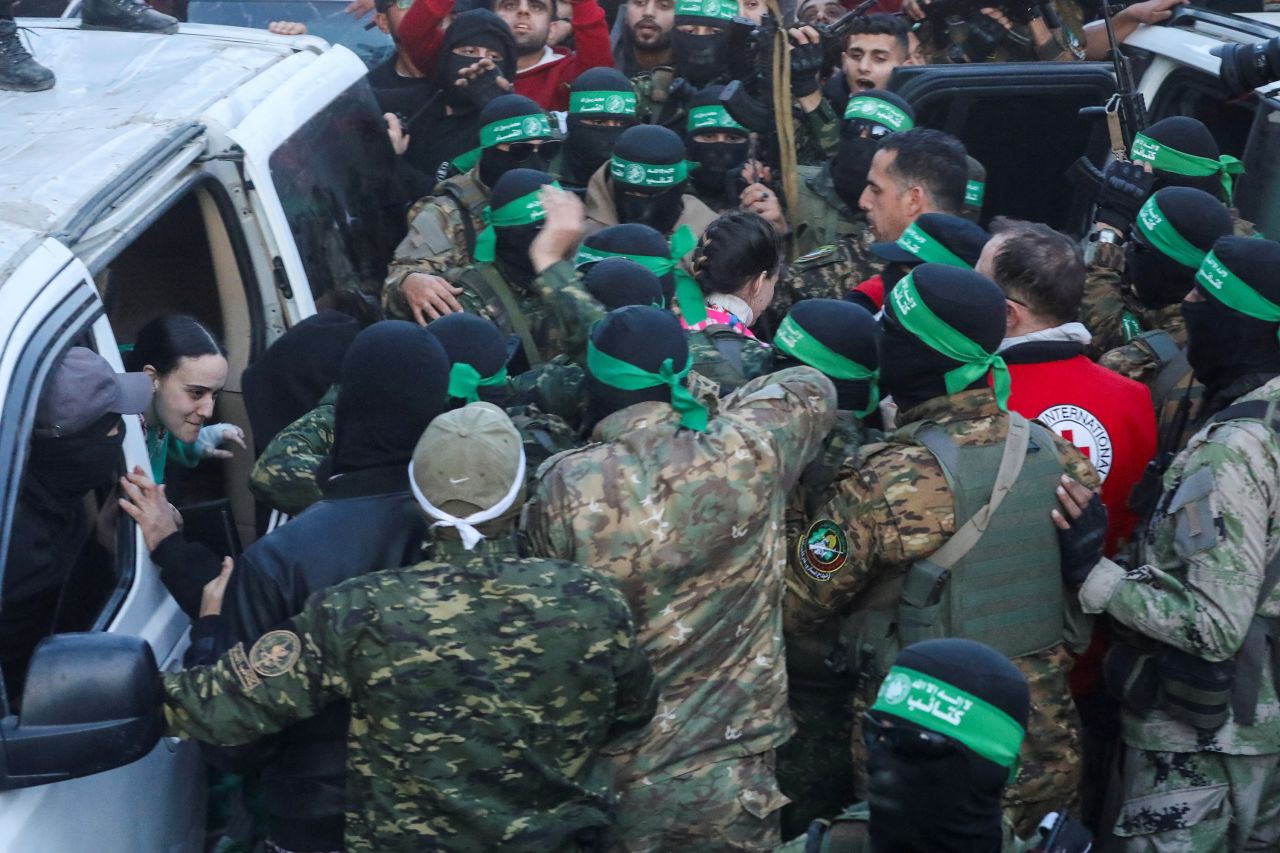 Hamas militants hand over hostages to members of the International Committee of the Red Cross in Gaza City on Sunday.