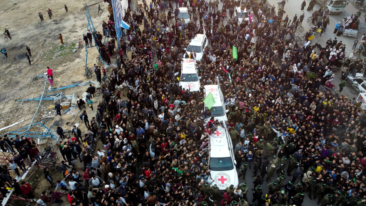 Palestinians and Hamas militants gather around Red Cross vehicles before the hostage handoff in Gaza City on Sunday.