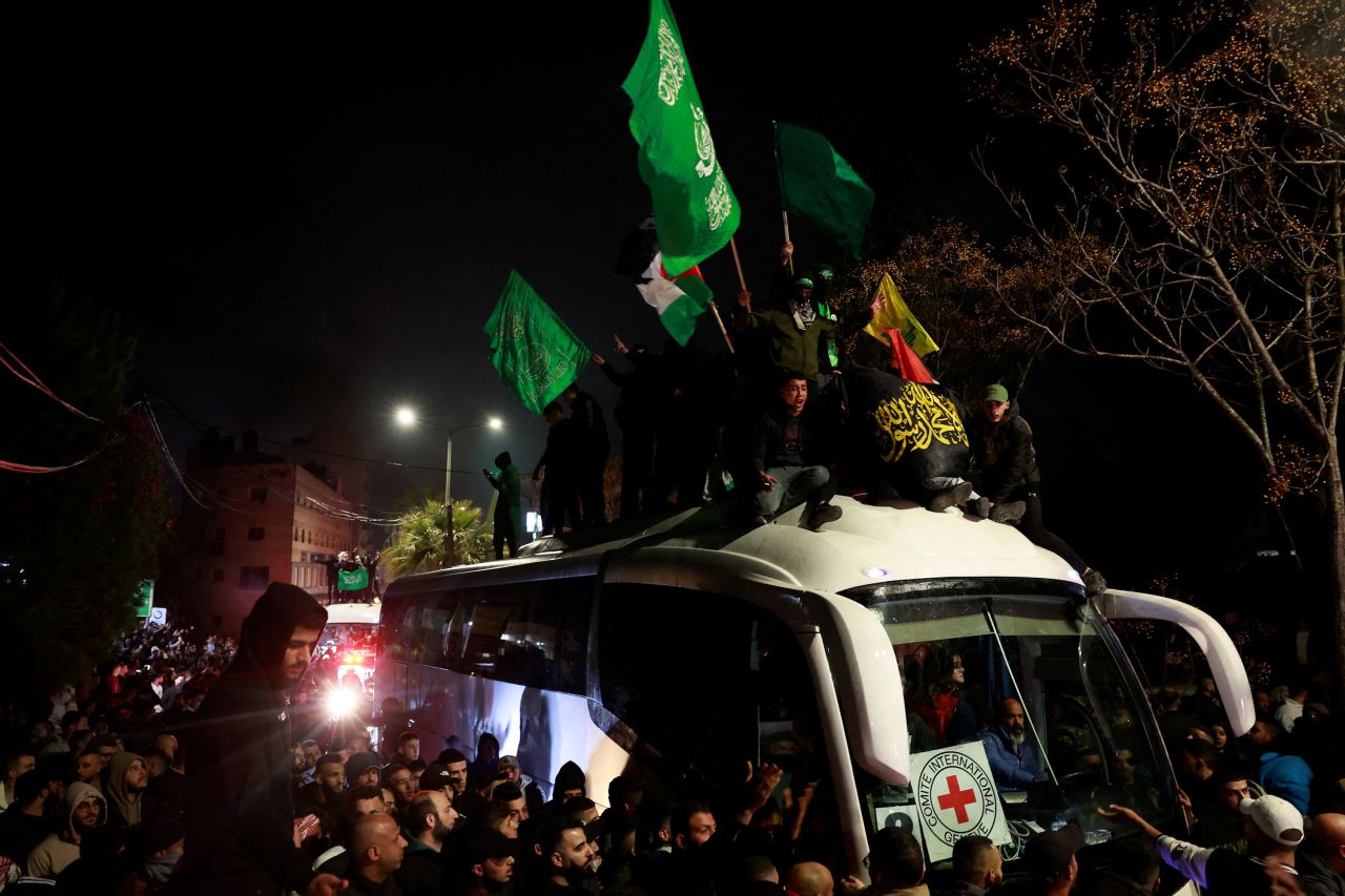 People gather around a bus carrying freed Palestinian prisoners after their release outside of Ofer prison in the occupied West Bank early Monday.