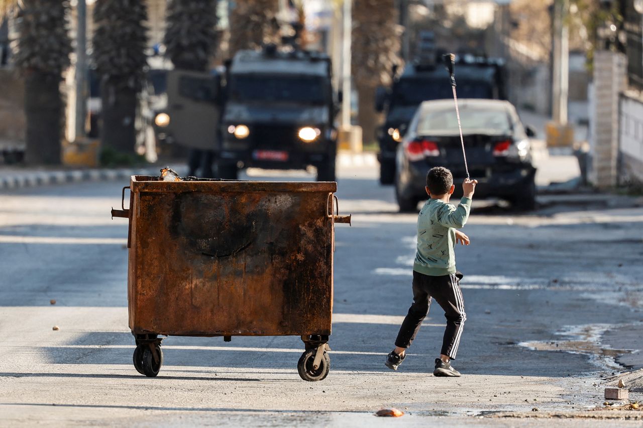 A Palestinian boy uses a sling to hurl a stone in the Israeli-occupied West Bank on Thursday.