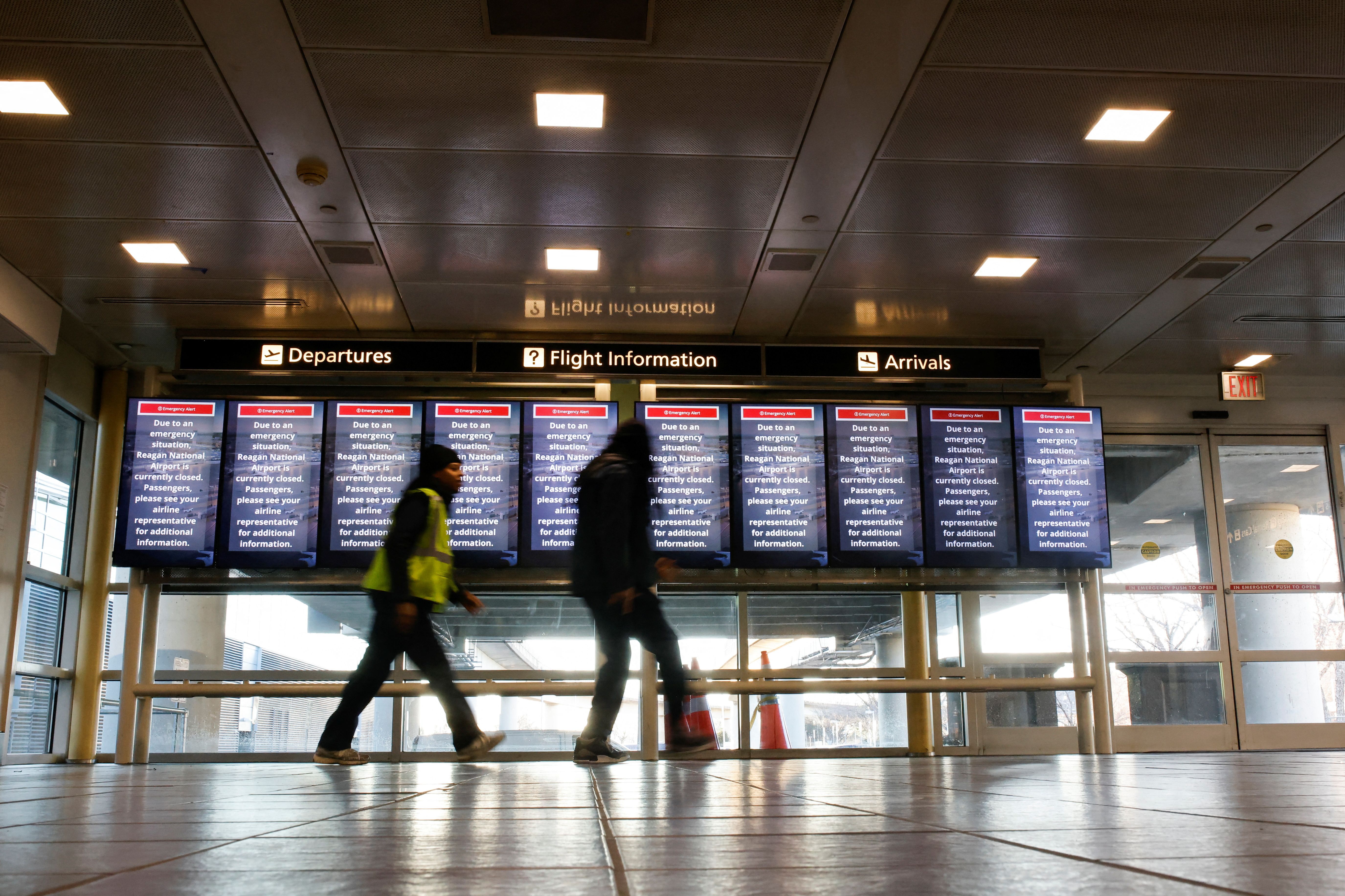 People walk past an emergency alert at Reagan National Airport on Thursday.