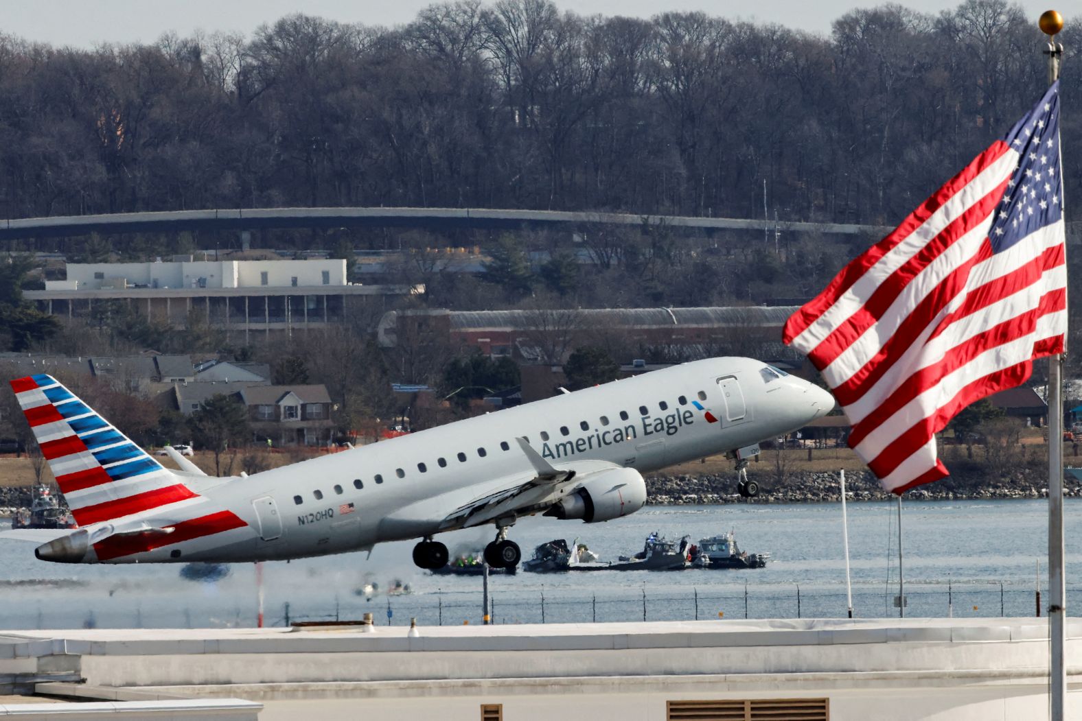 A plane takes off at Reagan National Airport on Thursday as work continues in the nearby Potomac.