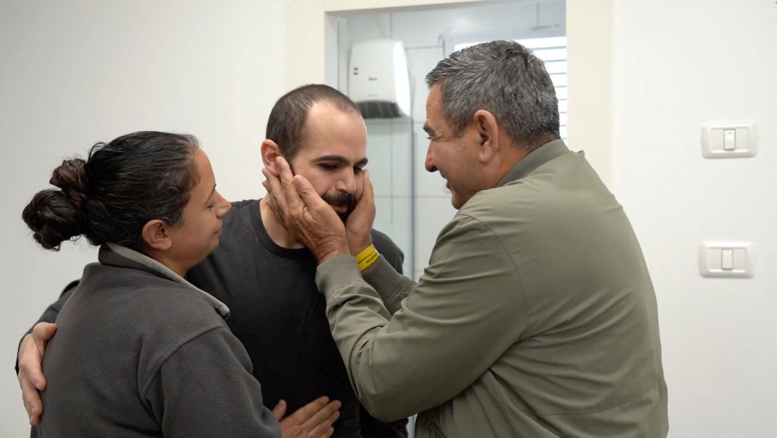 yarden bibas, released from captivity on saturday, is embraced by his father at an israeli military base at re'im.