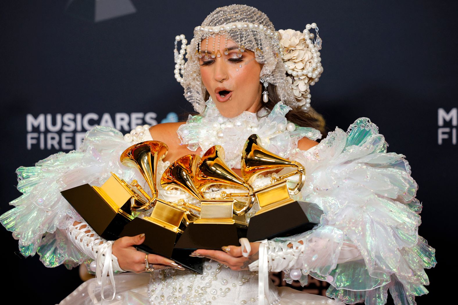 Sierra Ferrell poses in the press room with four Grammys she won before the main show. She won Grammys for best Americana album ("Trail of Flowers"), best Americana performance ("American Dreaming"), best American roots song ("American Dreaming") and best American roots performance ("Lighthouse").