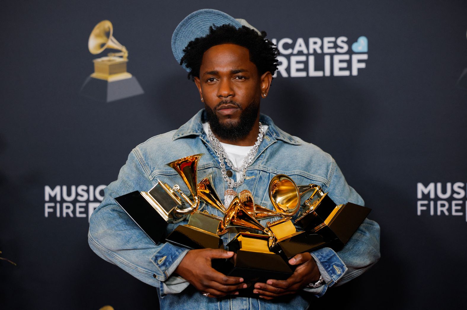 Kendrick Lamar poses in the press room with all the Grammys he won on Sunday.