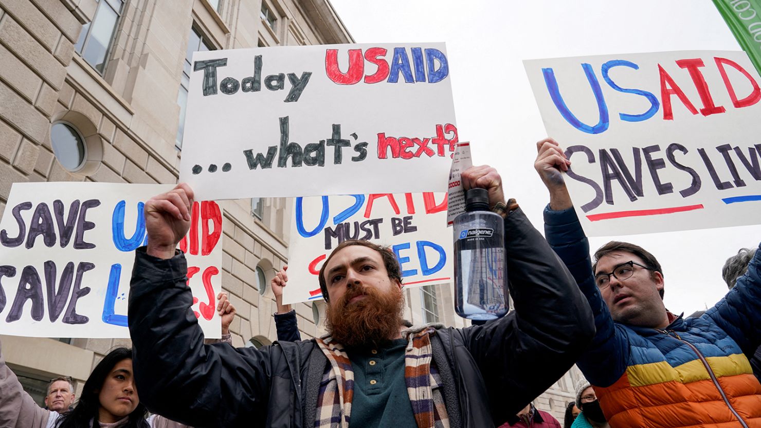 People hold placards outside the USAID building, after billionaire Elon Musk, who is heading President Donald Trump's drive to shrink the federal government, said work is underway to shut down the US foreign aid agency USAID, in Washington, DC, February 3, 2025.