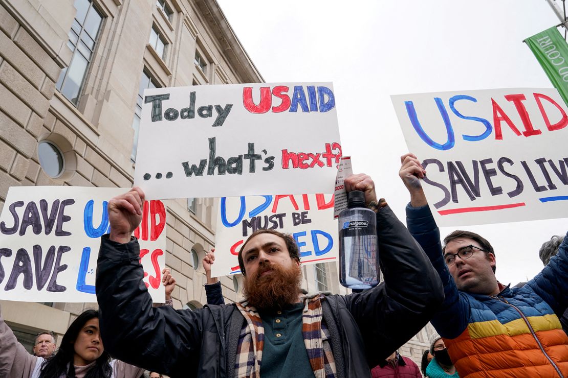 People hold placards outside the USAID building, after billionaire Elon Musk, who is heading U.S. President Donald Trump's drive to shrink the federal government, said work is underway to shut down the U.S. foreign aid agency USAID, in Washington, U.S., February 3, 2025.