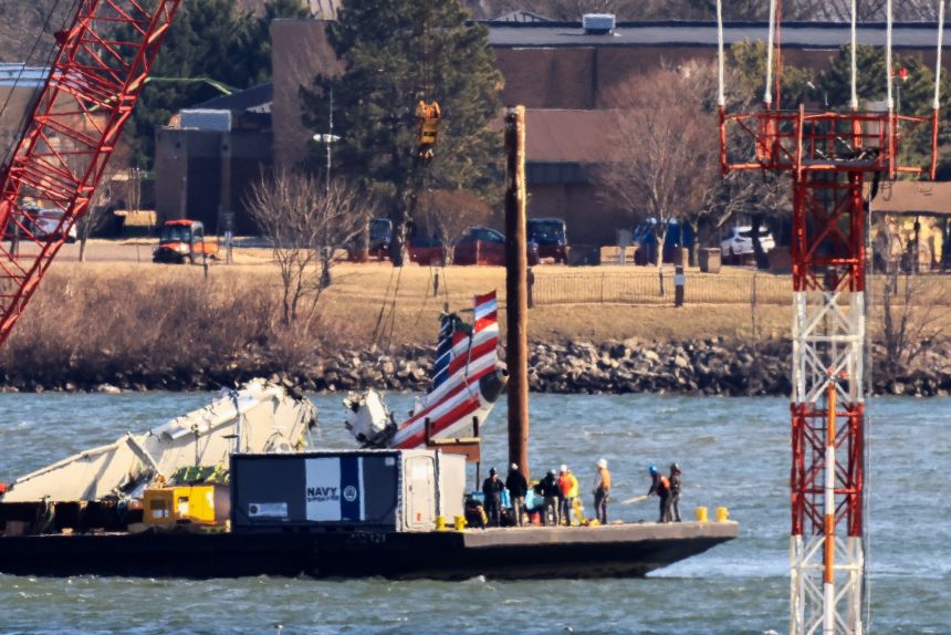 A crane recovers the tail of American Airlines flight 5342 near Ronald Reagan Washington National Airport on February 4, 2025.