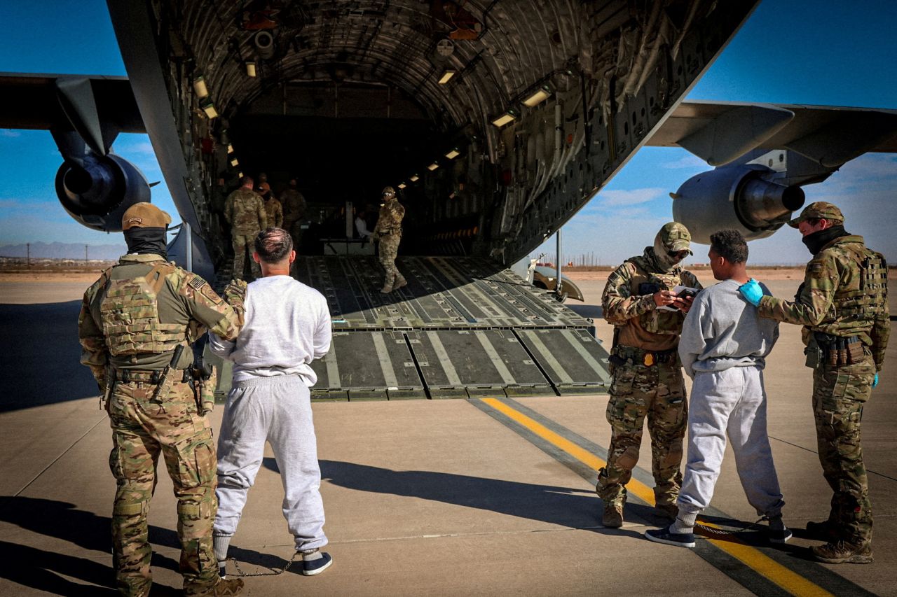 The first US military aircraft to carry detained migrants to a detention facility at Guantanamo Bay is boarded from an unspecified location in the US, on February 4.