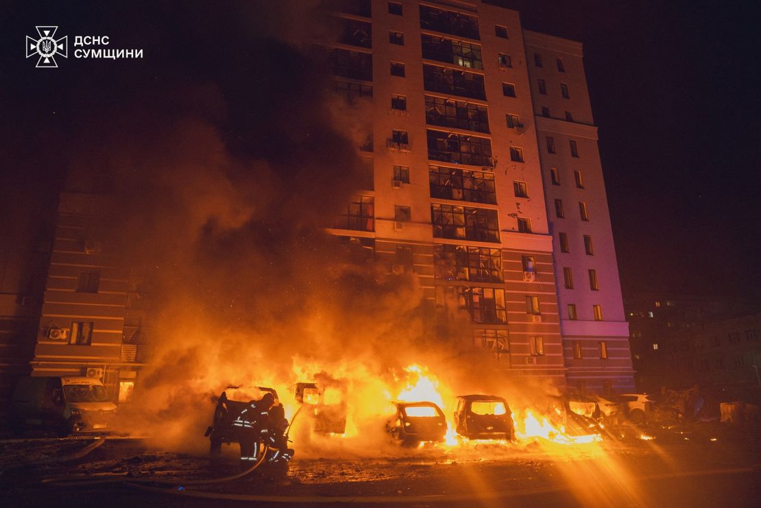 Firefighters respond to a Russian drone strike on a residential building in Sumy, Ukraine, on Monday.