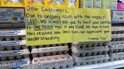 A sign for customers shopping for eggs at Trader Joe's hangs by cartons of eggs in in a New York store.