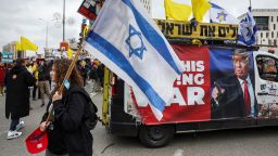 A woman carries an Israeli flag next to a banner with an image of U.S. President Donald Trump, during a demonstration calling for the immediate return of hostages held in Gaza, amid a ceasefire between Israel and Hamas, outside Prime Minister office in Jerusalem February 11, 2025. REUTERS/Ronen Zvulun