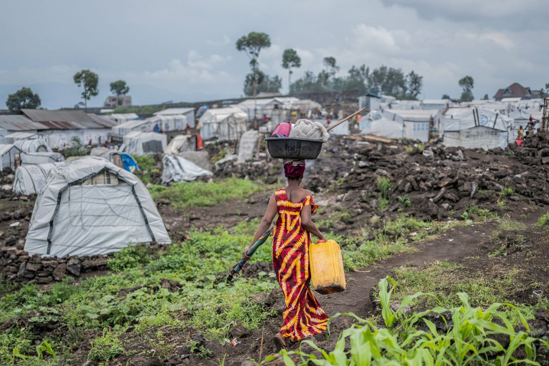 A woman displaced by recent clashes between M23 rebels and Congolese armed forces, prepares to leave a camp on the outskirts of Goma, after being ordered to do so by the rebels, on February 12.