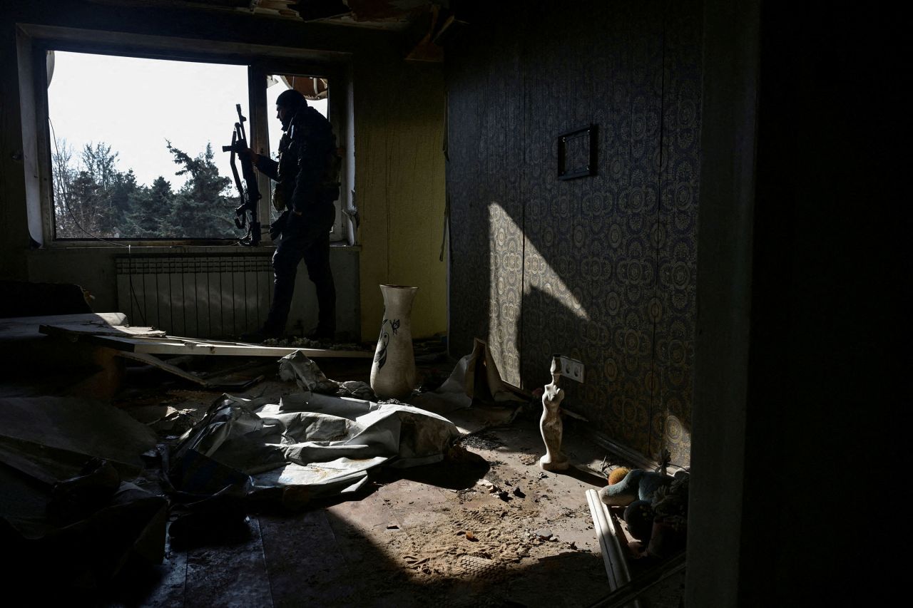 A police officer watches for Russian drones from an apartment building damaged by Russian military strikes in Orikhiv, Ukraine, on Wednesday.