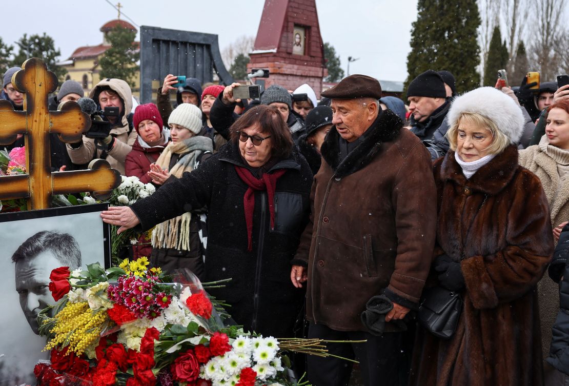 Navalny's parents, Lyudmila and Anatoly (center left), visit their son's grave at a Moscow cemetery on Sunday with Alla Abrosimova (right), the mother of his widow.