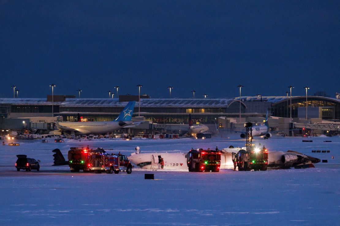 Emergency responders operate around the plane Monday at Toronto Pearson International Airport. REUTERS/Cole Burston