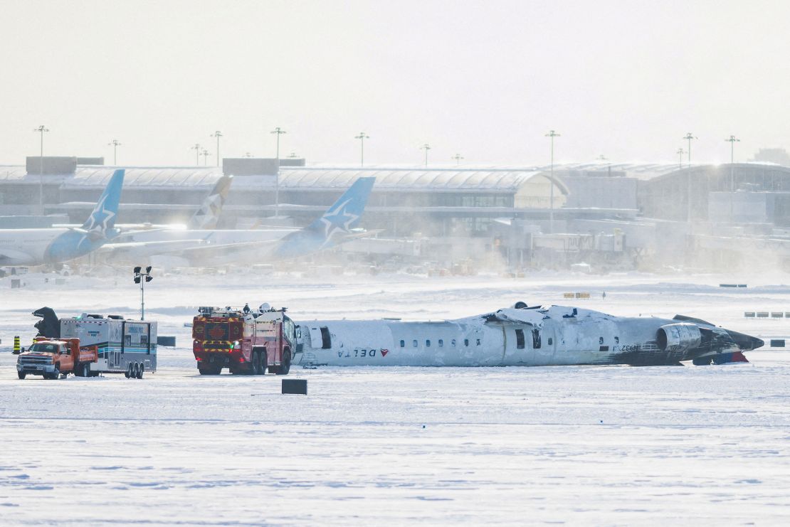 The wreckage of the Delta Line Bombardier CRJ900 aircraft was upside down on the runway at Toronto Pearson International Airport on Tuesday.