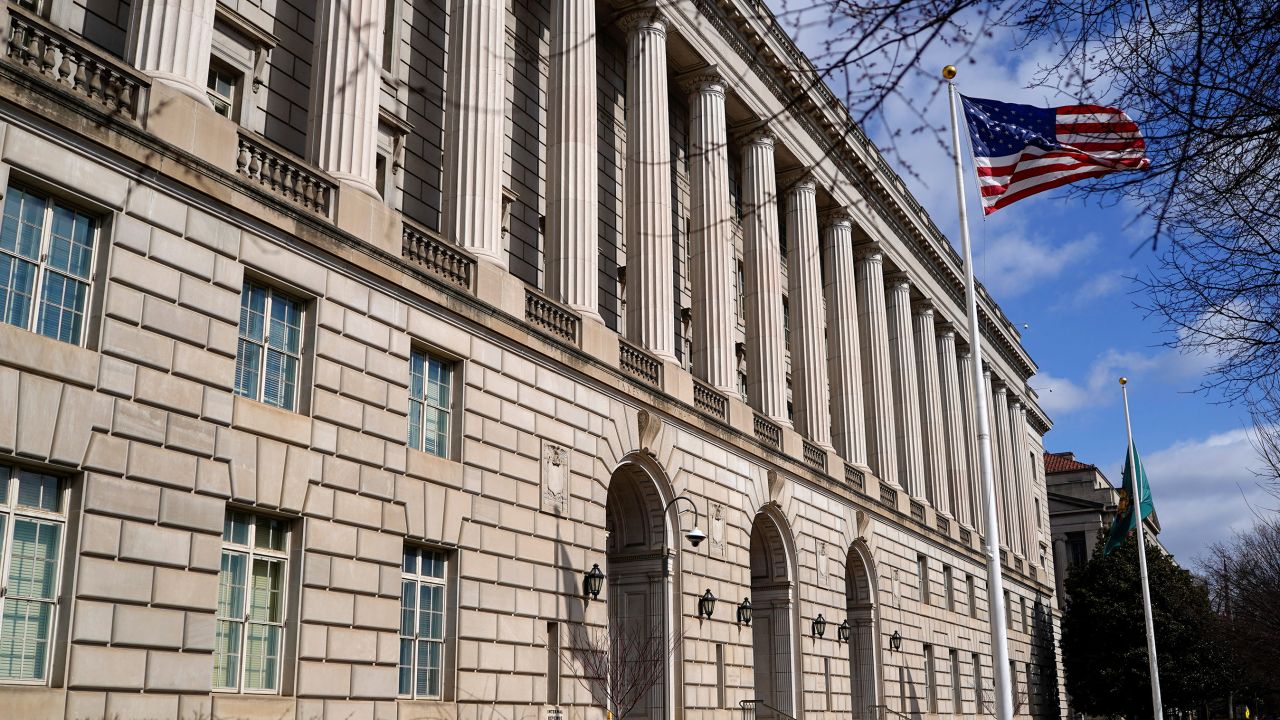 A U.S. flag flutters outside the U.S. Internal Revenue Service (IRS) building after it was reported the IRS will lay off about 6,700 employees, a restructuring that could strain the tax-collecting agency's resources during the critical tax-filing season, in Washington, D.C., February 20, 2025.