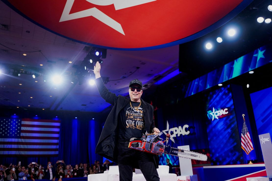 Elon Musk holds a chainsaw onstage at the Conservative Political Action Conference (CPAC) in National Harbor, Maryland, on February 20, 2025.